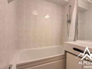 Discover this charming bathroom featuring a bathtub and a stylish sink.