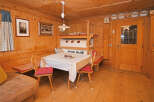 Step into this charming cabin retreat, featuring a cozy dining area with a rustic wooden table and chairs.