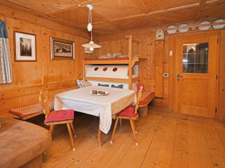 Step into this charming cabin retreat, featuring a cozy dining area with a rustic wooden table and chairs.