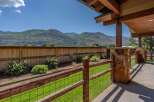 Enjoy breathtaking mountain views from this stunning property, featuring a spacious backyard with a wooden fence and lush green lawn.