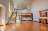 Experience grand living in this spacious open-concept home featuring a stunning two-story living area with a dramatic staircase and a modern kitchen island.