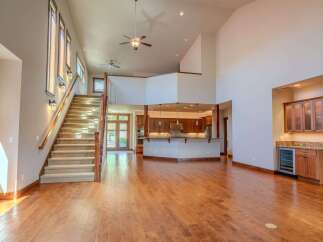 Experience grand living in this spacious open-concept home featuring a stunning two-story living area with a dramatic staircase and a modern kitchen island.
