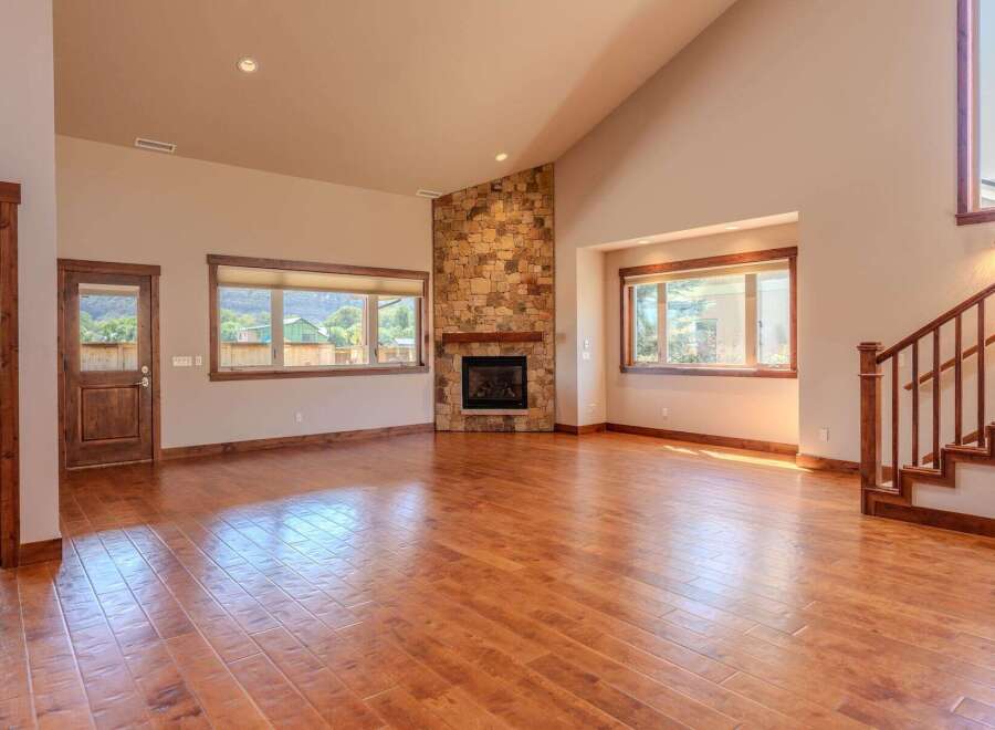 Experience the warmth and elegance of this spacious living room, featuring a stunning stone fireplace as the centerpiece.