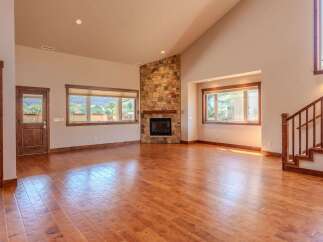 Experience the warmth and elegance of this spacious living room, featuring a stunning stone fireplace as the centerpiece.