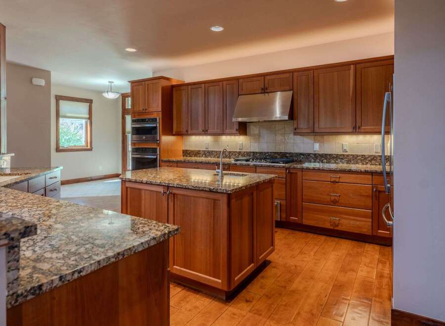 Experience luxury in this stunning kitchen featuring custom cherry wood cabinetry and granite countertops.