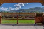 Enjoy breathtaking mountain views from this stunning property, framed by a rustic wooden fence and gate.
