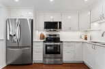 This stunning kitchen boasts modern stainless steel appliances, including a refrigerator, microwave, and oven.