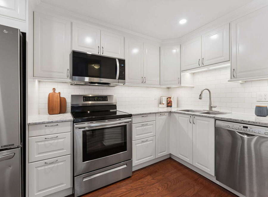 This stunning kitchen boasts a modern design with sleek white cabinetry and stainless steel appliances.