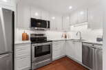 This stunning kitchen boasts a modern design with sleek white cabinetry and stainless steel appliances.