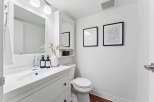 This modern bathroom features a sleek white vanity with a stylish sink and faucet.