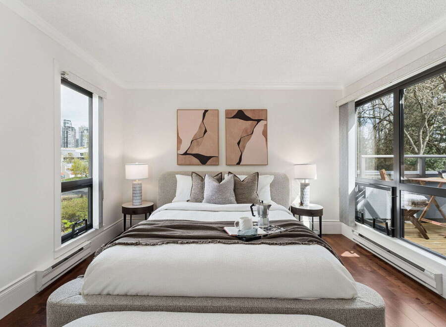 Experience luxury in this stunning bedroom featuring a cozy bed, elegant artwork, and ample natural light.