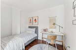 This cozy bedroom features a stylish design with a comfortable bed and a functional desk area.