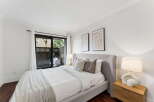 This stunning bedroom offers a serene retreat with its modern design and ample natural light.