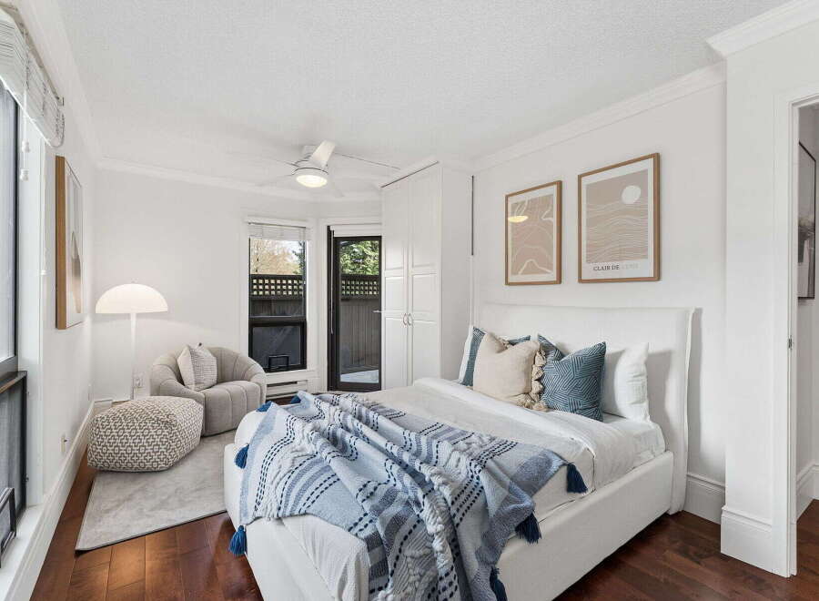 Step into this bright and airy bedroom, featuring a comfortable bed with stylish bedding and decorative pillows.
