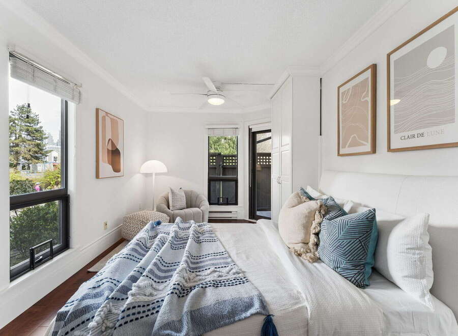 This bright and airy bedroom offers a serene retreat with its crisp white walls and ample natural light.