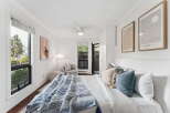 This bright and airy bedroom offers a serene retreat with its crisp white walls and ample natural light.