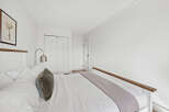 This inviting bedroom offers a serene retreat with its bright, airy ambiance and minimalist design.