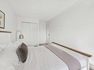 This inviting bedroom offers a serene retreat with its bright, airy ambiance and minimalist design.