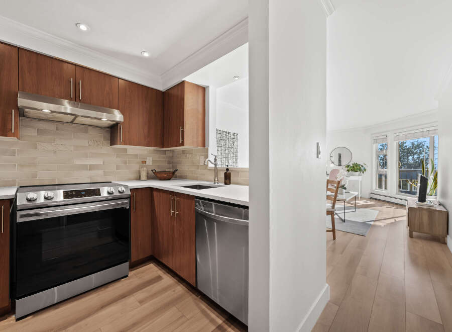 Step into this stunning kitchen, featuring sleek stainless steel appliances and rich wooden cabinetry.
