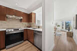 Step into this stunning kitchen, featuring sleek stainless steel appliances and rich wooden cabinetry.