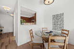This stunning dining area features a modern glass-top table and stylish wooden chairs, perfect for hosting gatherings.