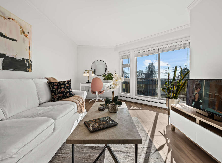 Experience modern living in this bright and airy condo, featuring a stylish living room with a comfortable white sofa and a chic coffee table.