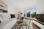 Experience modern living in this bright and airy condo, featuring a stylish living room with a comfortable white sofa and a chic coffee table.