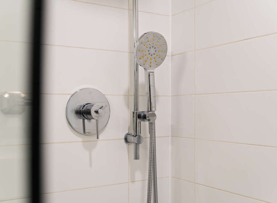 This modern bathroom features a sleek showerhead and faucet, perfect for a refreshing start to your day.