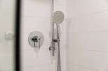 This modern bathroom features a sleek showerhead and faucet, perfect for a refreshing start to your day.