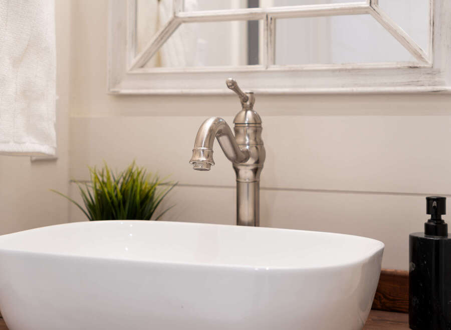 This stunning bathroom features a modern design with a sleek white sink and a stylish faucet.