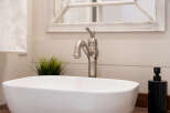 This stunning bathroom features a modern design with a sleek white sink and a stylish faucet.