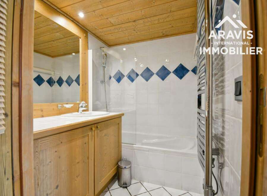 This charming bathroom features a wooden ceiling and cabinetry, creating a warm and inviting atmosphere.