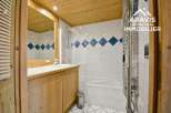 This charming bathroom features a wooden ceiling and cabinetry, creating a warm and inviting atmosphere.