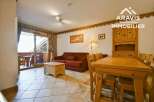 Discover a cozy living space with a charming wooden dining table and chairs, perfect for family gatherings.