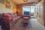 Discover the charm of this cozy property, featuring a comfortable living area with a rustic wooden sofa and a beautiful view.