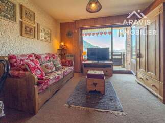 Discover the charm of this cozy property, featuring a comfortable living area with a rustic wooden sofa and a beautiful view.