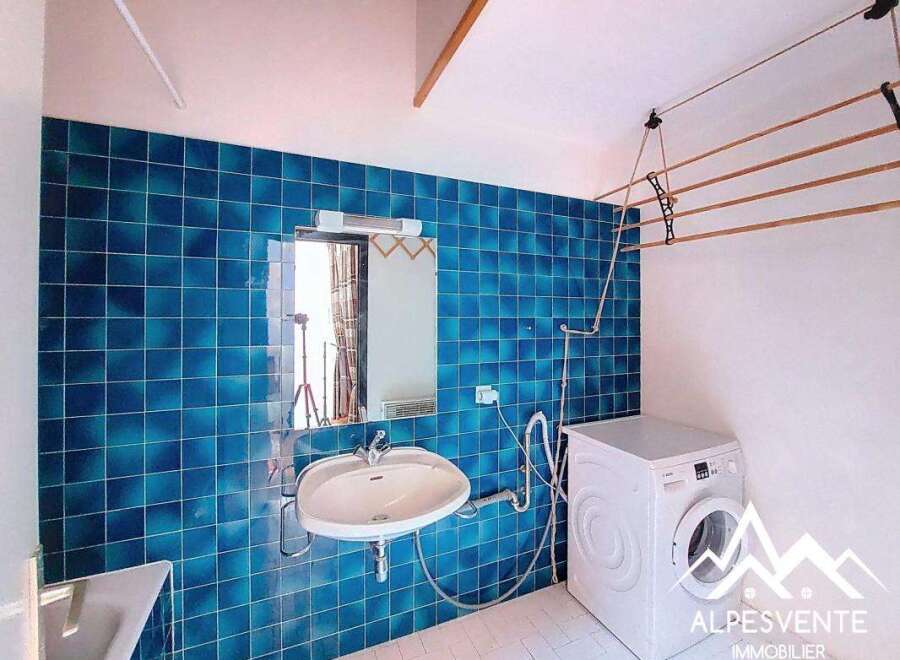 Discover this charming property featuring a modern laundry room with a washing machine and a convenient clothes drying rack.