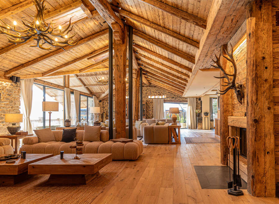 Experience rustic luxury in this stunning property, featuring exposed wooden beams, stone walls, and a cozy fireplace.