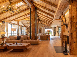 Experience rustic luxury in this stunning property, featuring exposed wooden beams, stone walls, and a cozy fireplace.