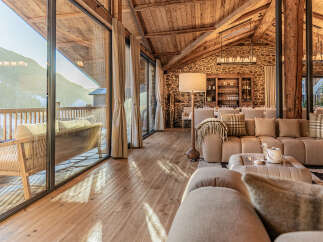 Experience luxury living in this stunning property, featuring a spacious living area with a cozy sofa and a beautiful wooden floor.
