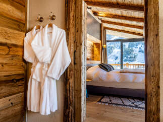 Step into luxury with this stunning property, showcasing a cozy bedroom with a breathtaking mountain view.