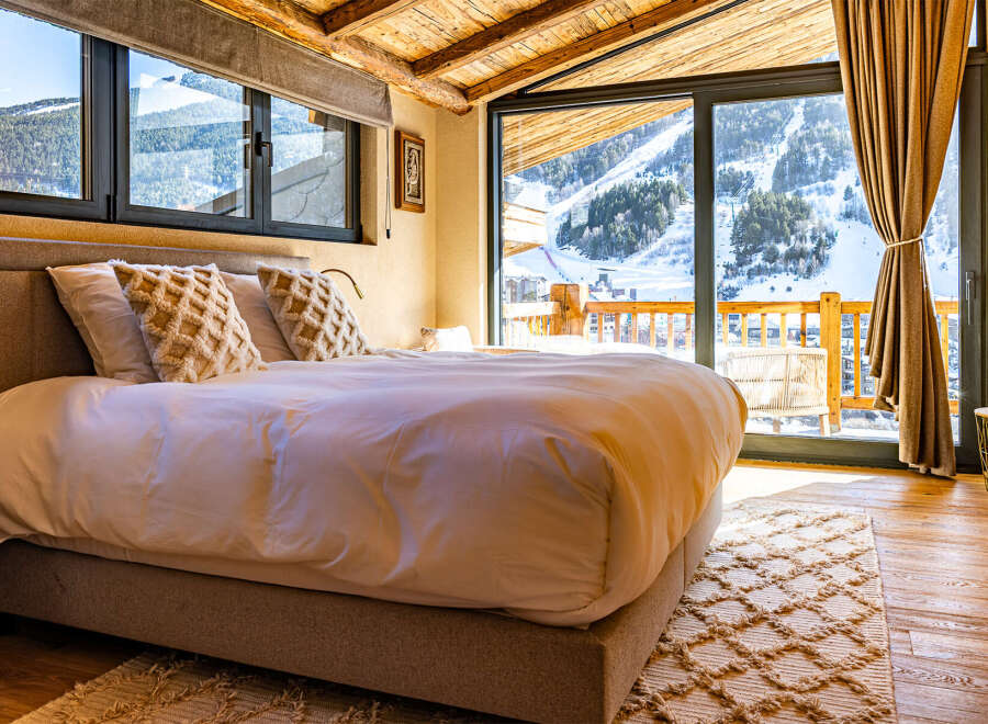 Experience the ultimate in luxury and comfort in this stunning bedroom with breathtaking mountain views.