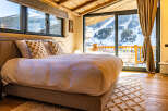 Experience the ultimate in luxury and comfort in this stunning bedroom with breathtaking mountain views.