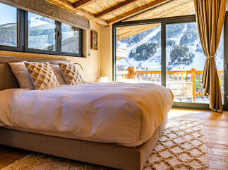 Experience the ultimate in luxury and comfort in this stunning bedroom with breathtaking mountain views.