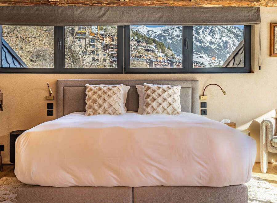 Experience luxury living with this stunning property, boasting breathtaking mountain views visible from the bedroom's expansive windows.
