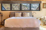 Experience luxury living with this stunning property, boasting breathtaking mountain views visible from the bedroom's expansive windows.