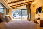 Experience luxury living in this stunning bedroom with breathtaking mountain views.