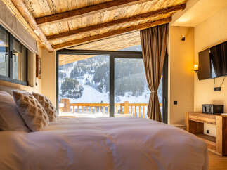 Experience luxury living in this stunning bedroom with breathtaking mountain views.