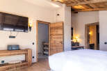 Experience rustic elegance in this stunning bedroom, featuring a beautiful wooden ceiling and doors that exude warmth and charm.