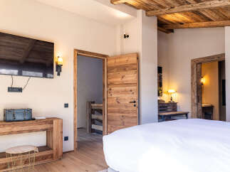 Experience rustic elegance in this stunning bedroom, featuring a beautiful wooden ceiling and doors that exude warmth and charm.